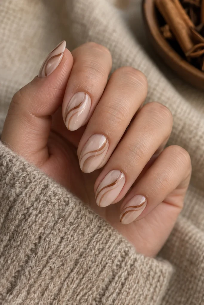 Neutral almond nails with flowing cinnamon and chocolate brown swirl art