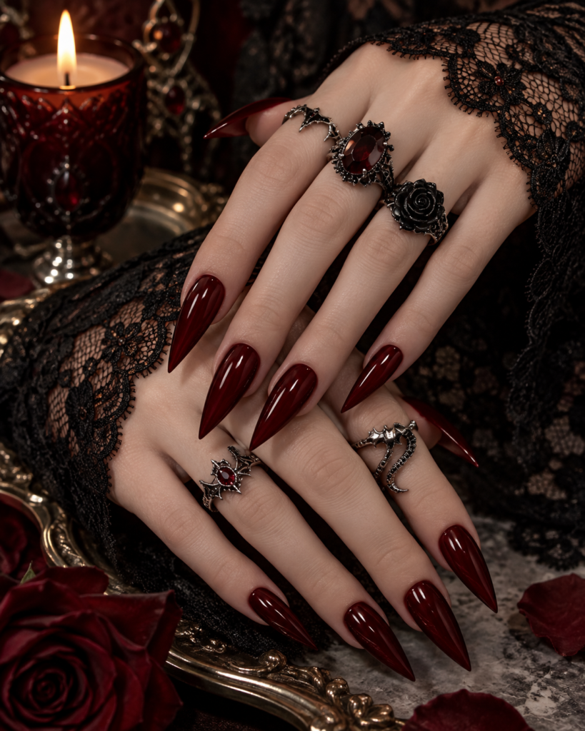 Dark burgundy vampire red stiletto Halloween nails with gothic jewelry